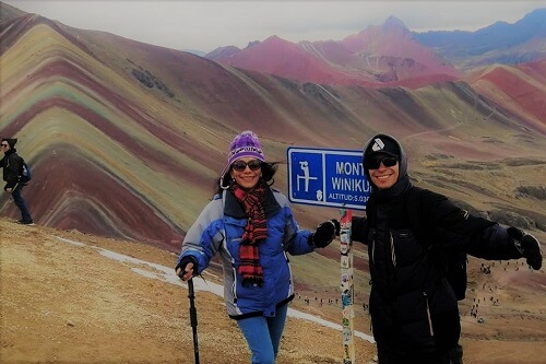 Tourists standing on Rainbow Mountain in Peru
